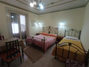 1 Schlafzimmer mit 2 Betten, einem Stuhl und einem Fenster in der Unterkunft ALLOGGIO DEI MILLE in Palermo