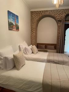 two beds in a hotel room with a mirror at Riad Amalia in Marrakech