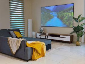 sala de estar con sofá azul y TV de pantalla plana en 12pax-4Br3.5Ba2Lvr/BM/Juru/100in Proj/AutoCity/Ikea, en Simpang Ampat