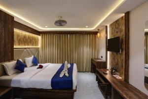 Habitación de hotel con cama y TV en RAMYA RESIDENCY, en Navi Mumbai
