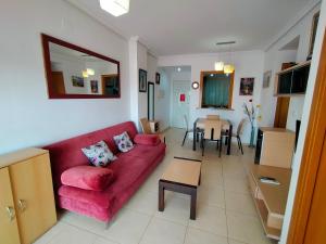 - un salon avec un canapé rouge et une table dans l'établissement ACV - Aguamarina - 2 linea planta 6 sur, à Oropesa del Mar
