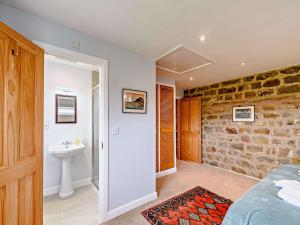 a bedroom with a stone wall and a sink at 8 Bed in Ripon 72263 in Grantley