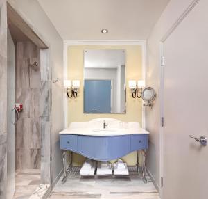 y baño con lavabo azul y espejo. en Grand Bohemian Hotel Charlotte, Autograph Collection en Charlotte