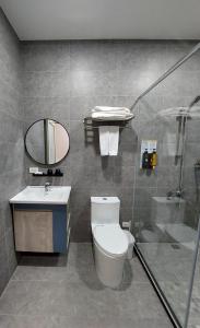La salle de bains est pourvue de toilettes, d'un lavabo et d'une douche. dans l'établissement 清境依山舞林民宿, à Renai