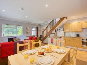 a kitchen and living room with a table with plates of food at Fernhill Cottage, Jurassic Coast in Charmouth