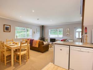 a kitchen and living room with a table and chairs at Fernhill Cottage, Jurassic Coast in Charmouth +27 photos