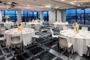 a conference room with white tables and chairs and windows at Le Méridien Chicago - Oakbrook Center in Oak Brook