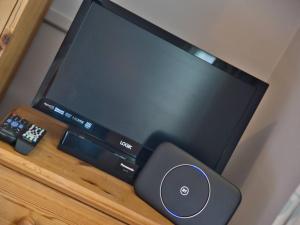 a flat screen tv sitting on top of a table at Fernhill Cottage, Jurassic Coast in Charmouth