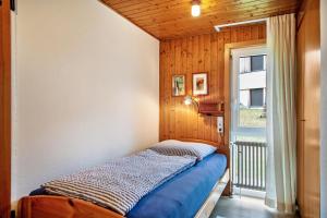 ein kleines Schlafzimmer mit einem Bett und einem Fenster in der Unterkunft Ferienhaus Rommel in Stiefenhofen