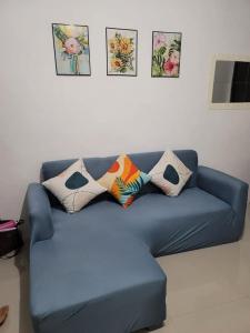 un sofá azul en una sala de estar con fotos en la pared en BELLA 1, en Cabanatúan