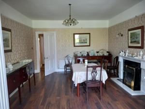 a dining room with a table and a fireplace at Carraig Rua in Kilkenny