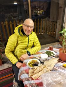un hombre sentado en una mesa con comida en The guset house, en Kerak