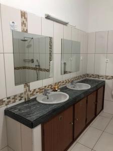 馬普托的住宿－Kutenga Guest House，一间带两个盥洗盆和大镜子的浴室