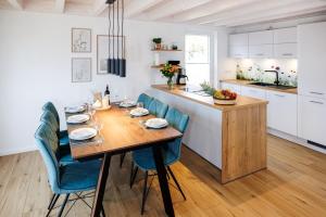 een keuken met een houten tafel en blauwe stoelen bij Vechteufer in Nordhorn
