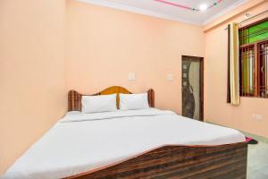 a bedroom with a large bed with white sheets at OYO Hotel Kukas Guest House in Jaipur