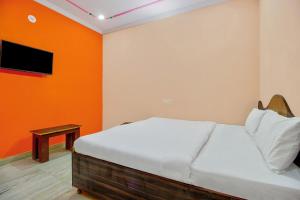 um quarto com uma cama com uma parede laranja em OYO Hotel Kukas Guest House em Jaipur