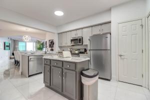 a kitchen with white cabinets and a stainless steel refrigerator at Gorgeous Oceanview 3BR Luxury Condo - Latitude in Gulfport
