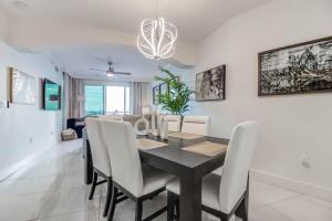 a dining room with a black table and white chairs at Gorgeous Oceanview 3BR Luxury Condo - Latitude in Gulfport