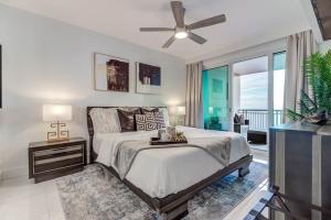a bedroom with a bed and a ceiling fan at Gorgeous Oceanview 3BR Luxury Condo - Latitude in Gulfport