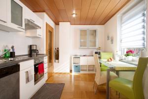 Bodensee Apartment Gresser في ميكنبورن: مطبخ مع طاولة وكراسي وقمة كونتر