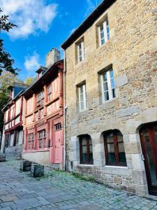 ein altes Backsteingebäude mit roten Türen auf einer Straße in der Unterkunft Le Cottage Breton, hypercentre historique StB in Saint-Brieuc