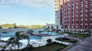 an aerial view of a building with two pools at Cozy 1BR Prime World District, Near Airport, Gaisano Grand Mall, Mactan Doctor's Hospital in Agus
