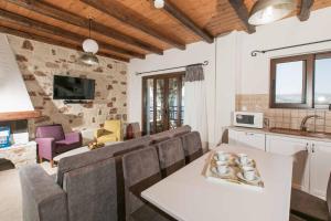 a kitchen and living room with a table and chairs at Villa Aptera in Kalami