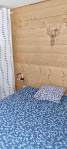 a bedroom with a blue bed with a pillow at Appartement très lumineux in Égat