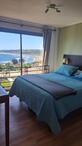 1 dormitorio con 1 cama y vistas al océano en Yemanya Hostal, en Concón
