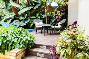 Four Roads的住宿－Garden Oasis 2 Villa With Private Pool，花园内带椅子和植物的木制甲板