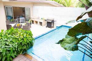 Four RoadsにあるGarden Oasis 2 Villa With Private Poolのテーブルと植物のあるスイミングプール