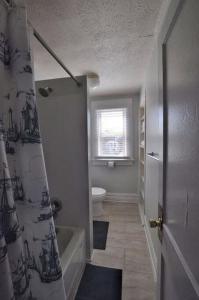 a bathroom with a tub and a toilet and a shower curtain at Housepitality - The Traveler's Townhouse in Columbus