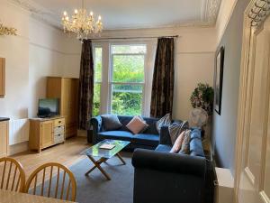 sala de estar con sofá azul y mesa en Barramore Holiday Apartments en Torquay