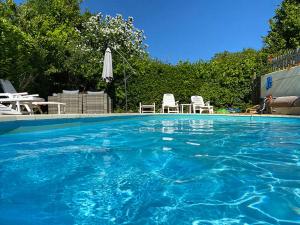una gran piscina con sillas y sombrilla en Barramore Holiday Apartments en Torquay