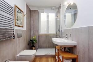 a bathroom with a sink and a toilet and a mirror at La Flavia Design City Suites Rome in Rome
