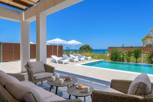 a patio with chairs and a swimming pool at Villa Panaxia Kohille in Theologos