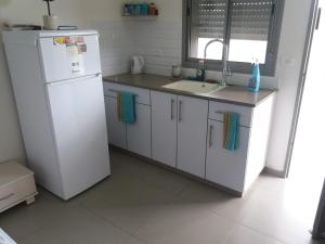 une cuisine avec un réfrigérateur blanc et un évier dans l'établissement צימר חספין, à Haspin 5 autres photos