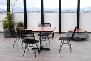 a table and chairs with a view of the city at Escenia Comfort, 9th floor apt with awesome views! in Guadalajara