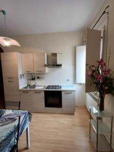 a kitchen with white cabinets and a stove top oven at Apartment L'aquila in LʼAquila