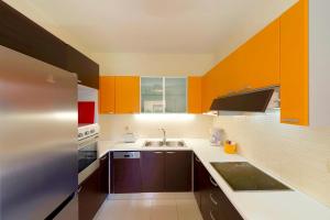 雷西姆農鎮的住宿－Villa Avra，厨房配有橙色和白色的橱柜和水槽