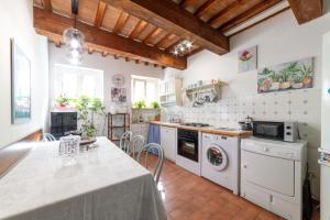 eine Küche mit weißen Geräten und einem Tisch in der Unterkunft Ca' Maggetti in Urbino