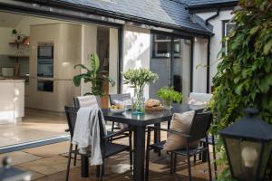 a dining table and chairs on a patio at Lower Mill - 3 Bedroom - 5* Retreat - Llangennith in Swansea