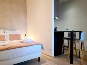 a bedroom with a bed and a table and a chair at Villa Saint Enogat in Aix-les-Bains