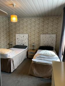 1 dormitorio con 2 camas y lámpara de araña en Villa Lyckan, en Söråker
