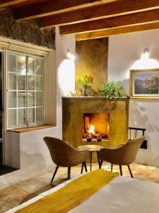 a living room with two chairs and a fireplace at Hotel Valle Místico in Tepoztlán