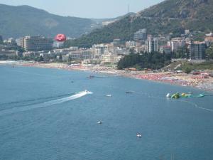 a beach with a bunch of people in the water at Apartments Danilo Kažanegra in Sveti Stefan