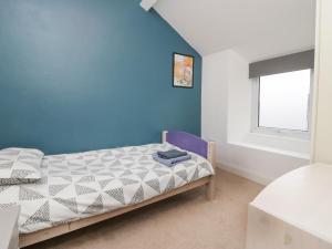 sypialnia z łóżkiem i niebieską ścianą w obiekcie 7 New Street w mieście Sedbergh