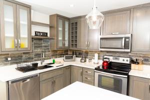 a kitchen with stainless steel appliances and wooden cabinets at Garden Oasis 2 Villa With Private Pool in Four Roads