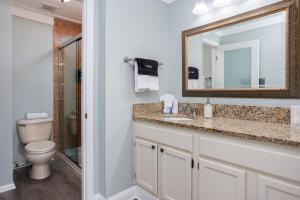 een badkamer met een toilet, een wastafel en een spiegel bij The Saint Augustine Beach House in St. Augustine