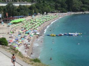 a group of people on a beach with umbrellas at Apartments Danilo Kažanegra in Sveti Stefan